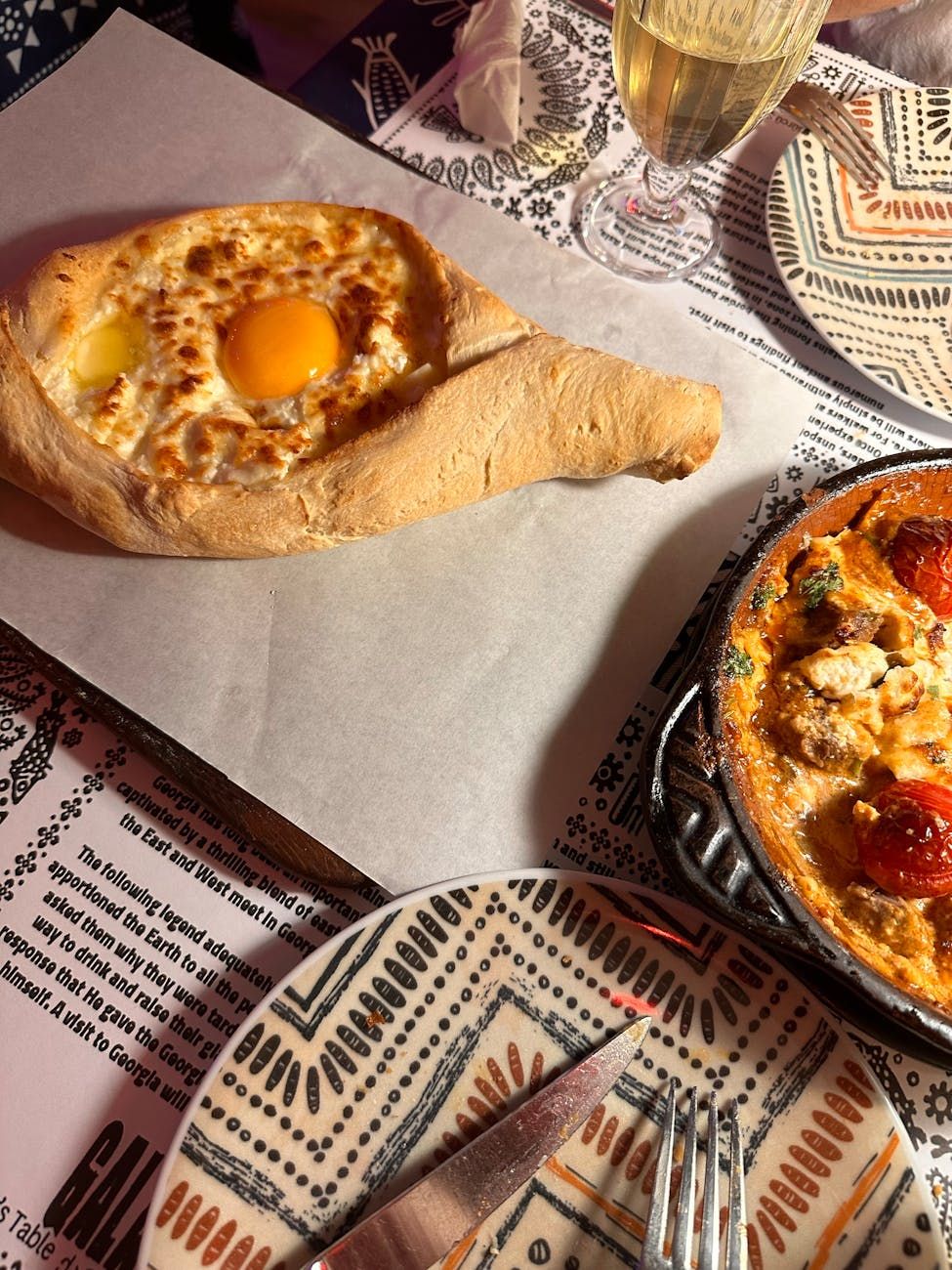 Adjarian Khachapuri, cucina georgiana, panino ripieno di formaggio a forma di barca, pasticcio tradizionale georgiano, ricetta del khachapuri, formaggio Sulguni, topping di tuorlo d'uovo, cibo caucasico, piatti autentici georgiani, khachapuri fatto in casa